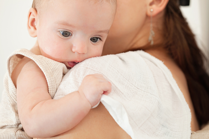 Mother holding baby boy on her shoulder