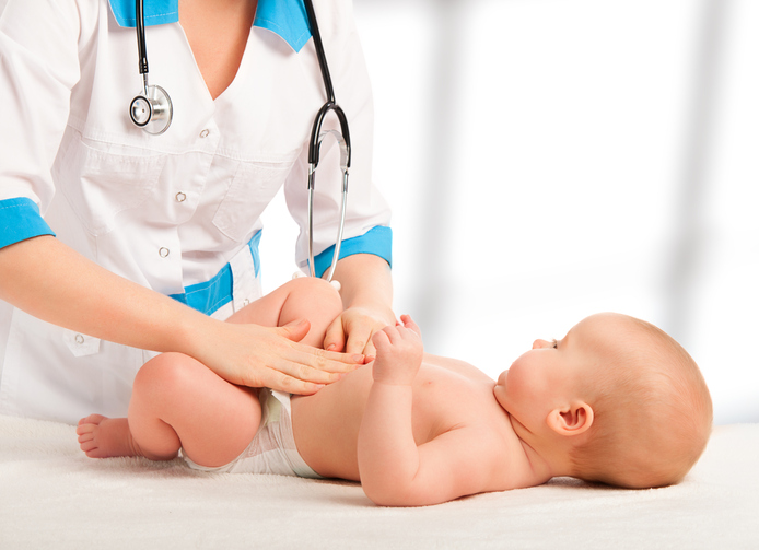 A Doctor examines and massaging baby tummy