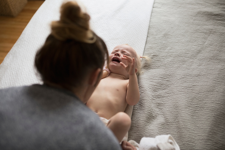 Mother changing crying baby girl