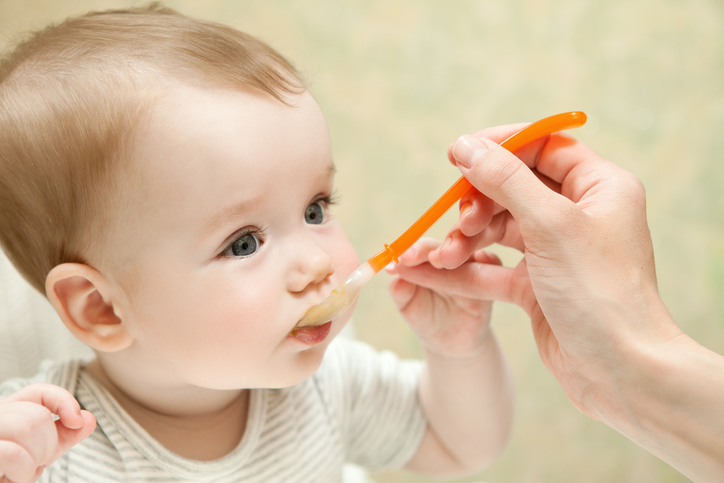 mother feeds baby boy baby food